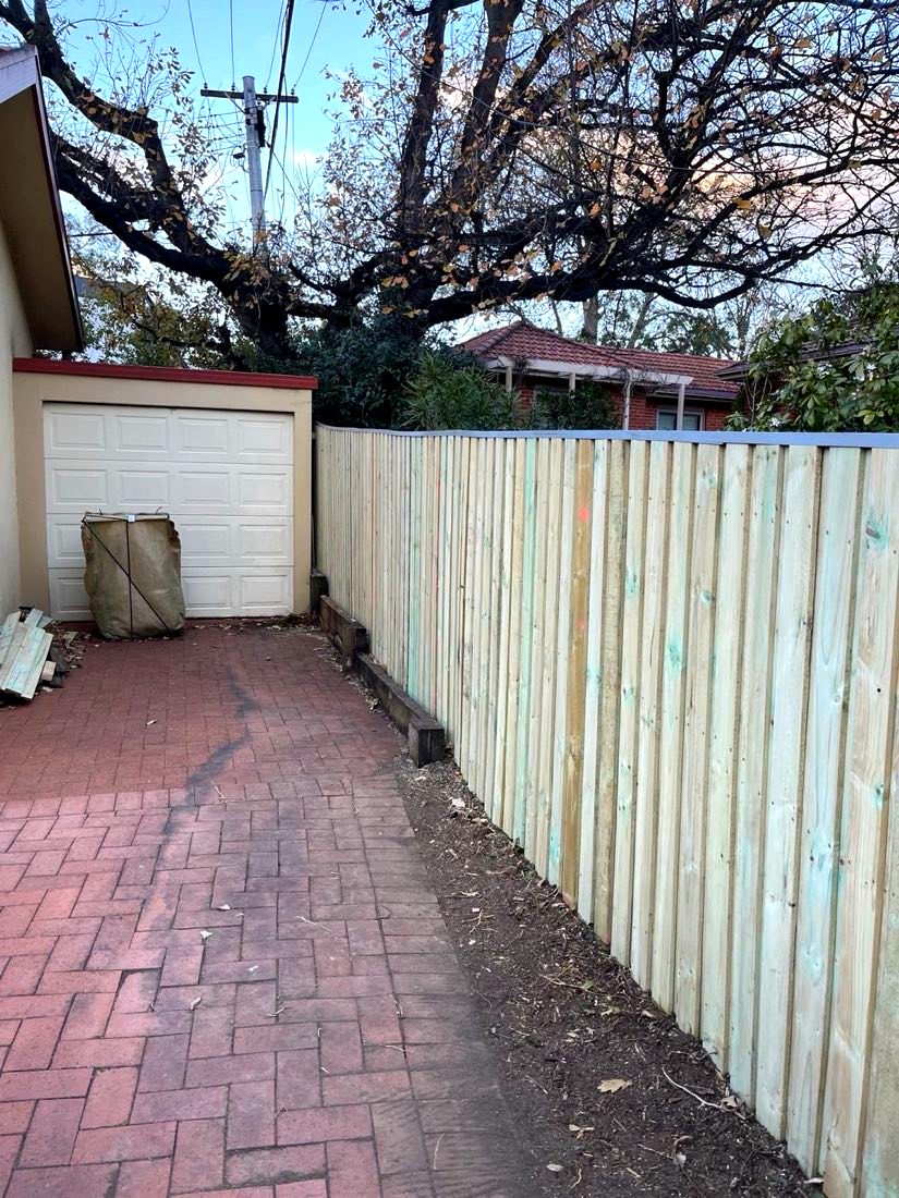 After: new capped timber paling fence on the true boundary, driveway clear end to end